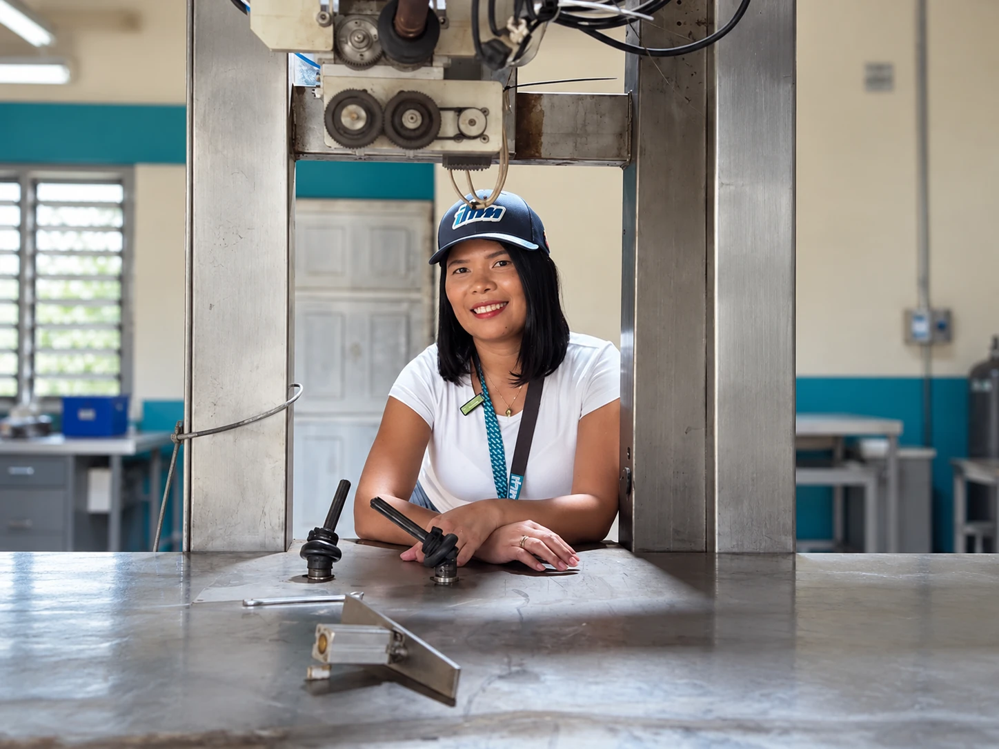 Integrante del equipo IHM en el taller, junto a una máquina de fabricación